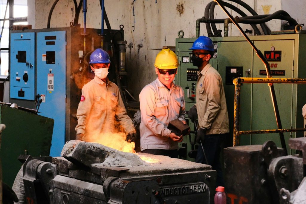 a group of people in hard hats standing around a machine