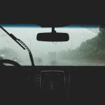 two person driving on rainy road