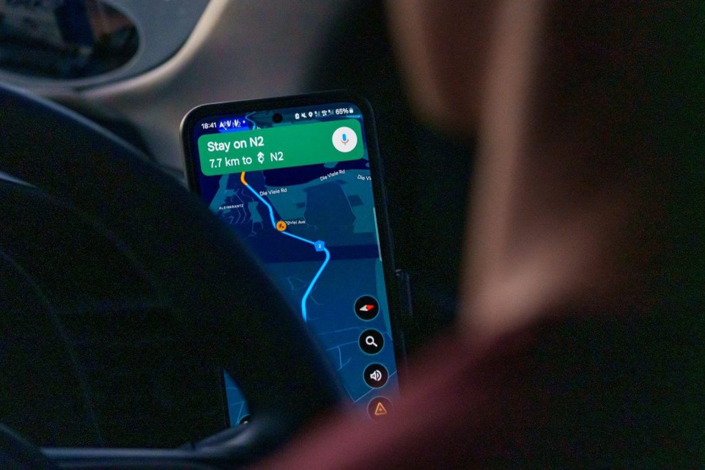 Person using navigation app on smartphone inside car.