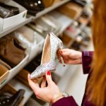 a woman looking at a pair of shoes in a shoe store