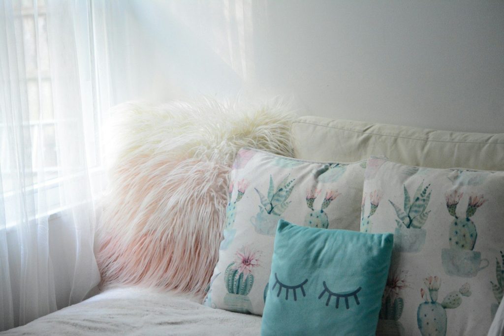 green throw pillow on white bed