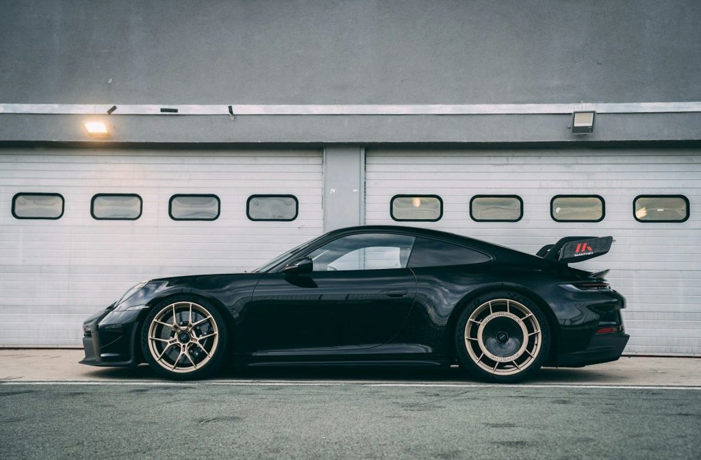 a black sports car parked in front of a garage