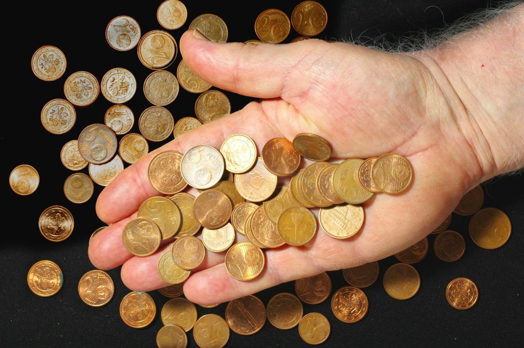 Coins are held in a hand.