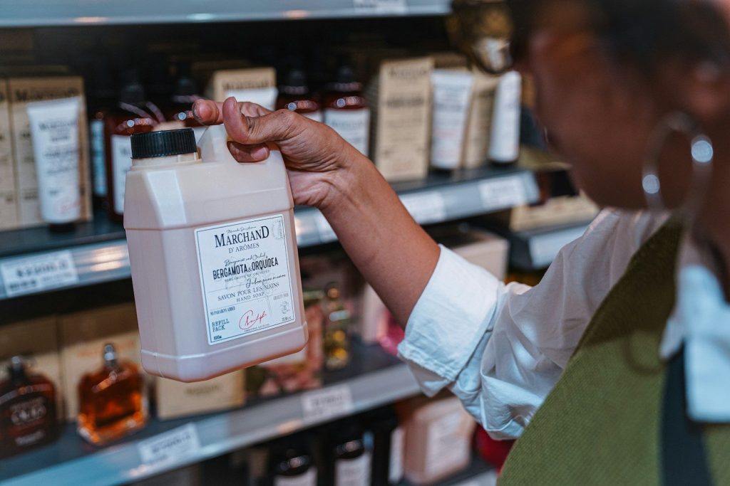 a woman holding a bottle of liquid in a store