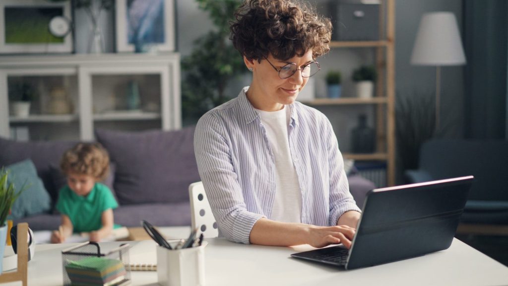 a woman sitting at a table using a laptop computer