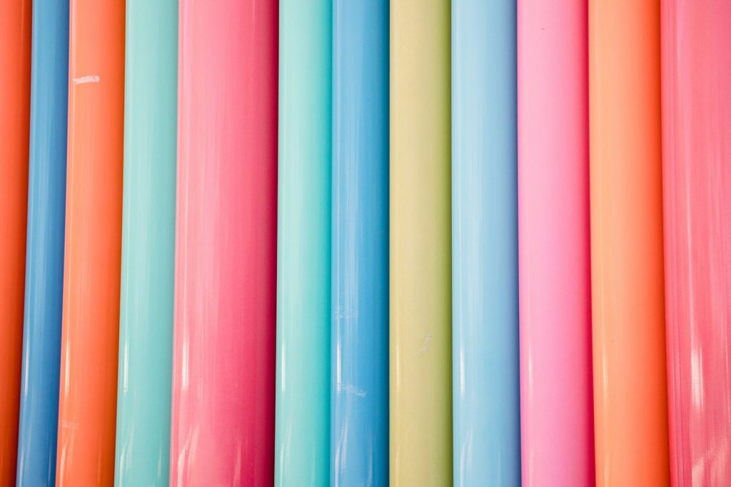 a bunch of different colored papers lined up together