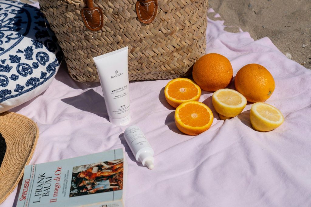 A beach picnic with fruit and skincare products.