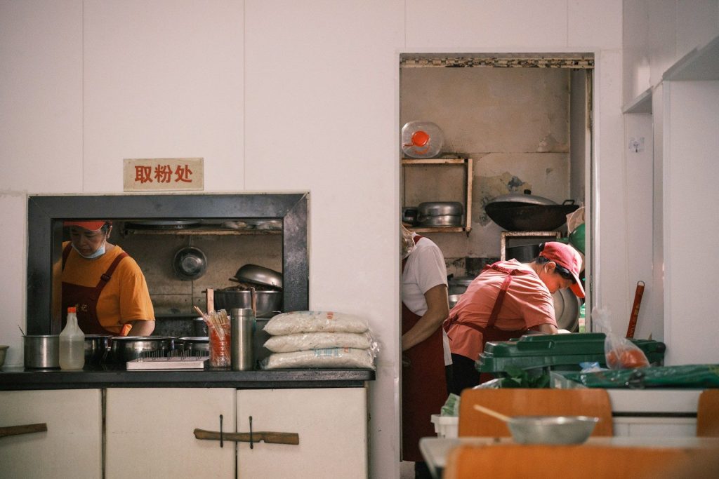 Chefs prepare food in a busy restaurant kitchen.