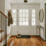 A cozy entryway with wooden stairs and a glass door.
