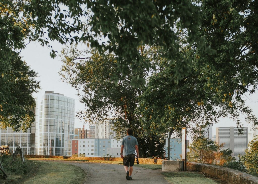 a man walking down a path in a park