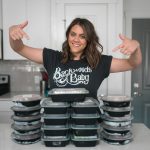 a woman standing in front of a stack of cake