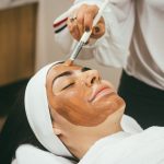 woman receiving facial mask treatment at spa