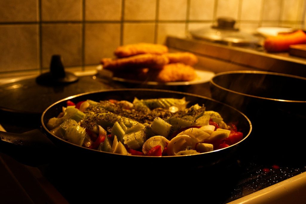 Fresh vegetables cooking in a pan on stove.