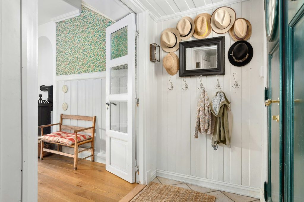 A room with a door and a bunch of hats on the wall