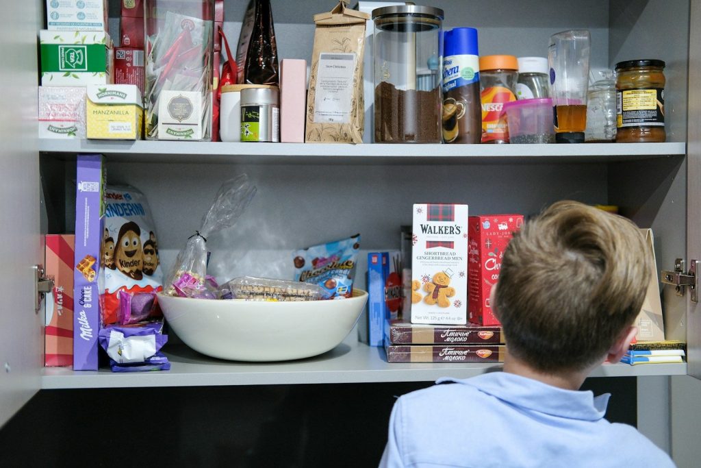 Boy looking at shelves filled with snacks and food.