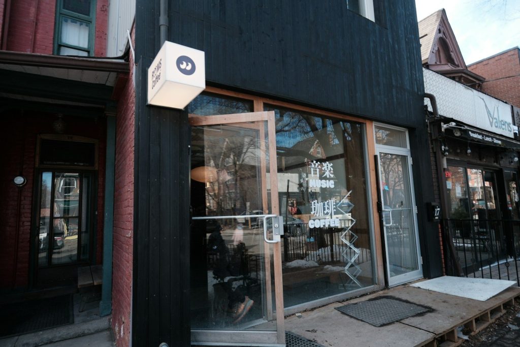 Modern black storefront with open glass doors.