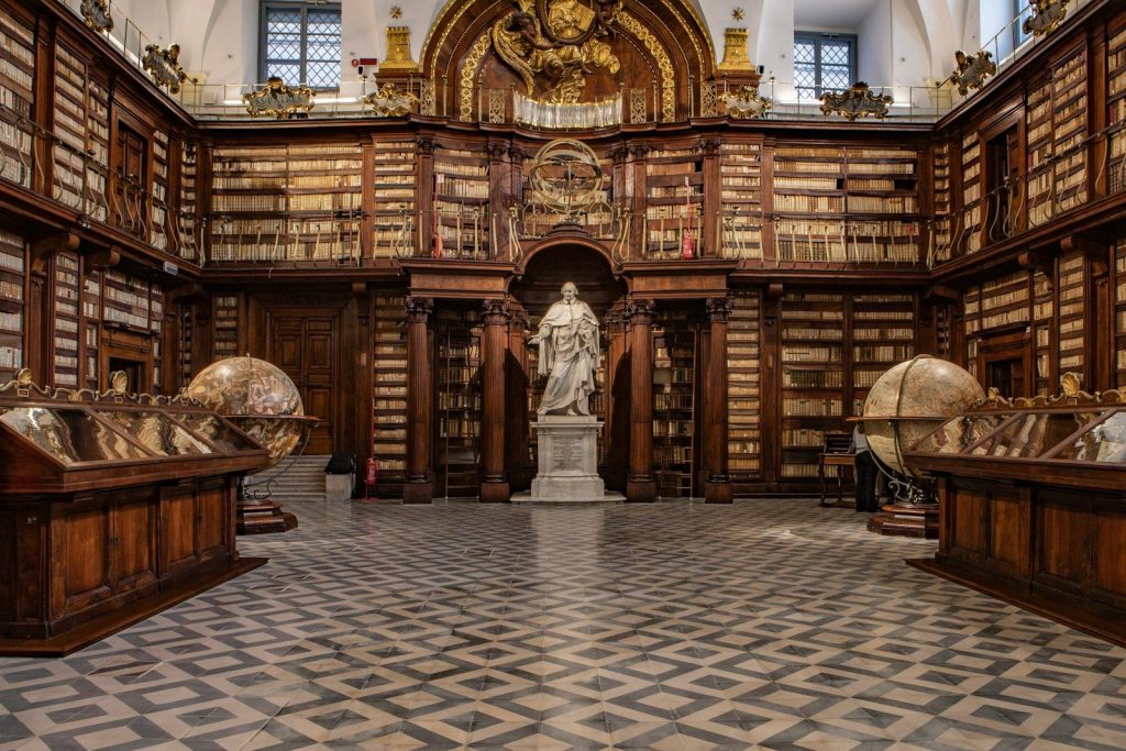 a large library with a statue in the middle of it
