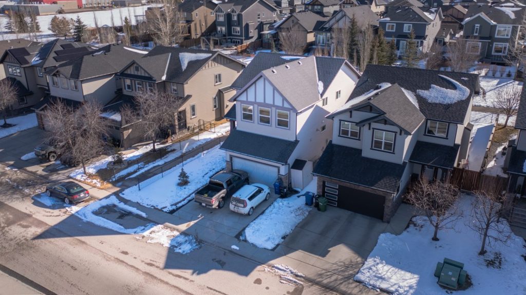 Aerial view of a suburban neighborhood with houses and snow.