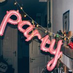 a pink balloon that says party hanging from a string