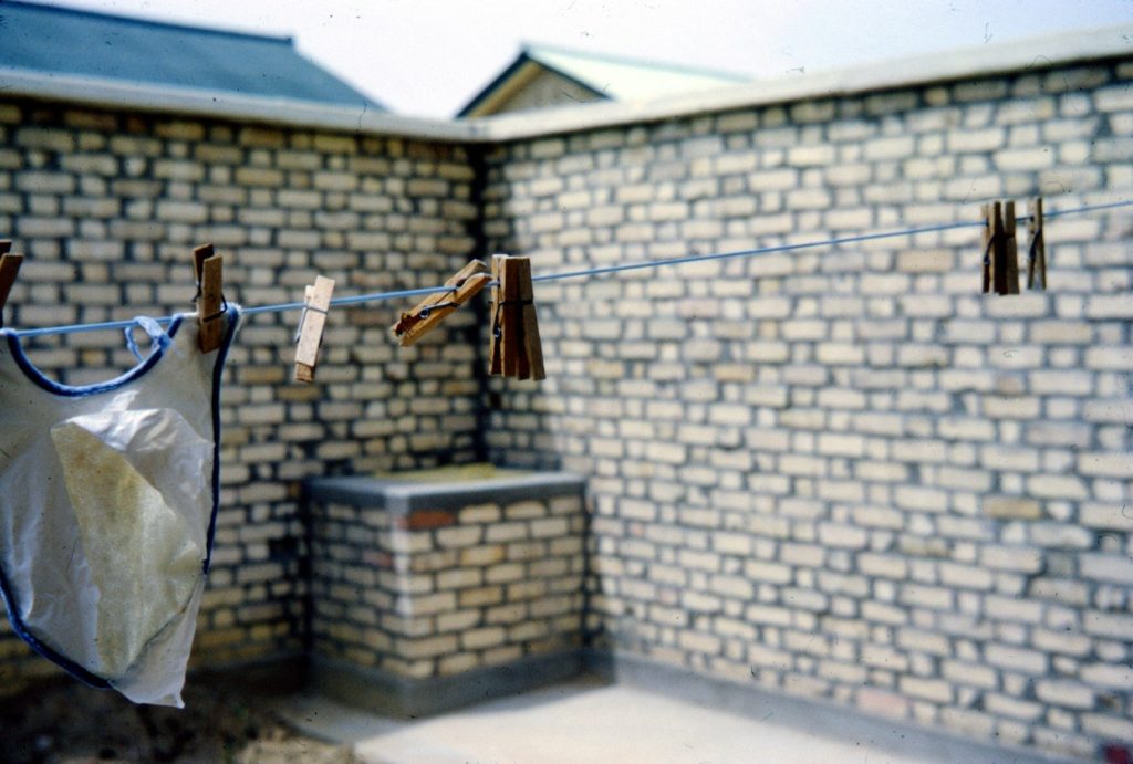 brown wooden cross on brown brick wall