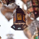 selective focus photography of hanging candle lantern