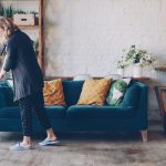 Woman cleaning the floor in a modern living room.