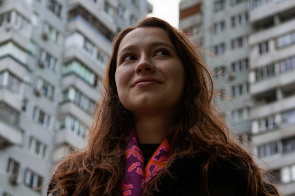 a woman standing in front of a tall building