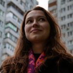 a woman standing in front of a tall building