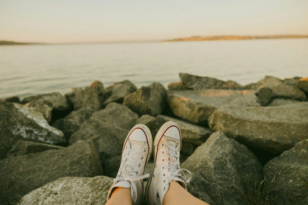 a pair of feet on rocks by the water