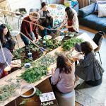 women crafting with greenery at workshop table