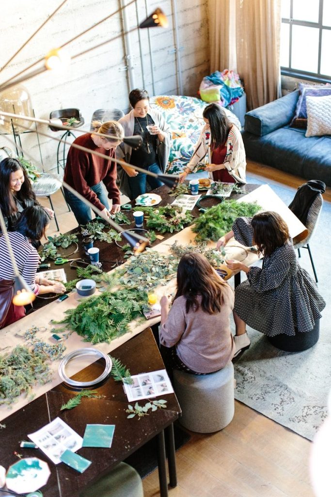 women crafting with greenery at workshop table
