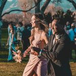 a man and a woman walking through a park