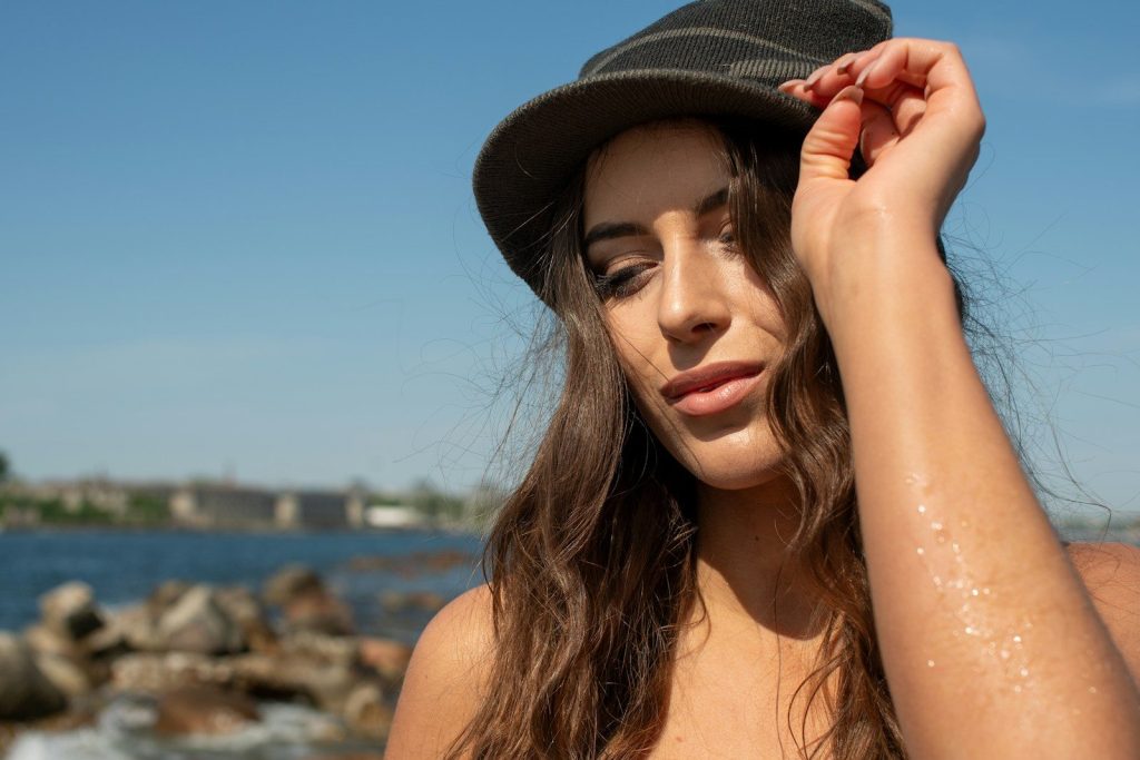 Young woman in hat by the water