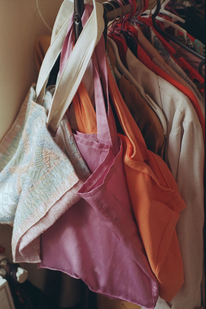 A vibrant display of tote bags and clothing on hangers inside a fashion boutique in Istanbul.