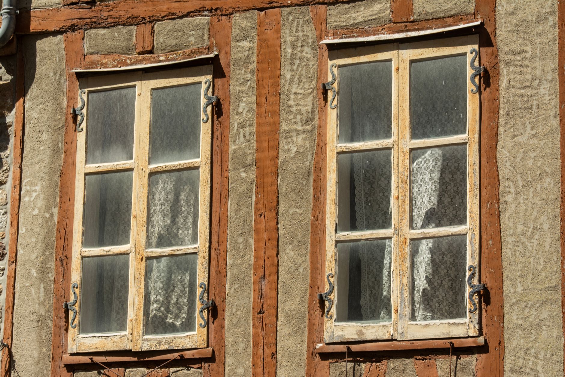 Close up of rustic vintage windows with wooden frames on a traditional facade.