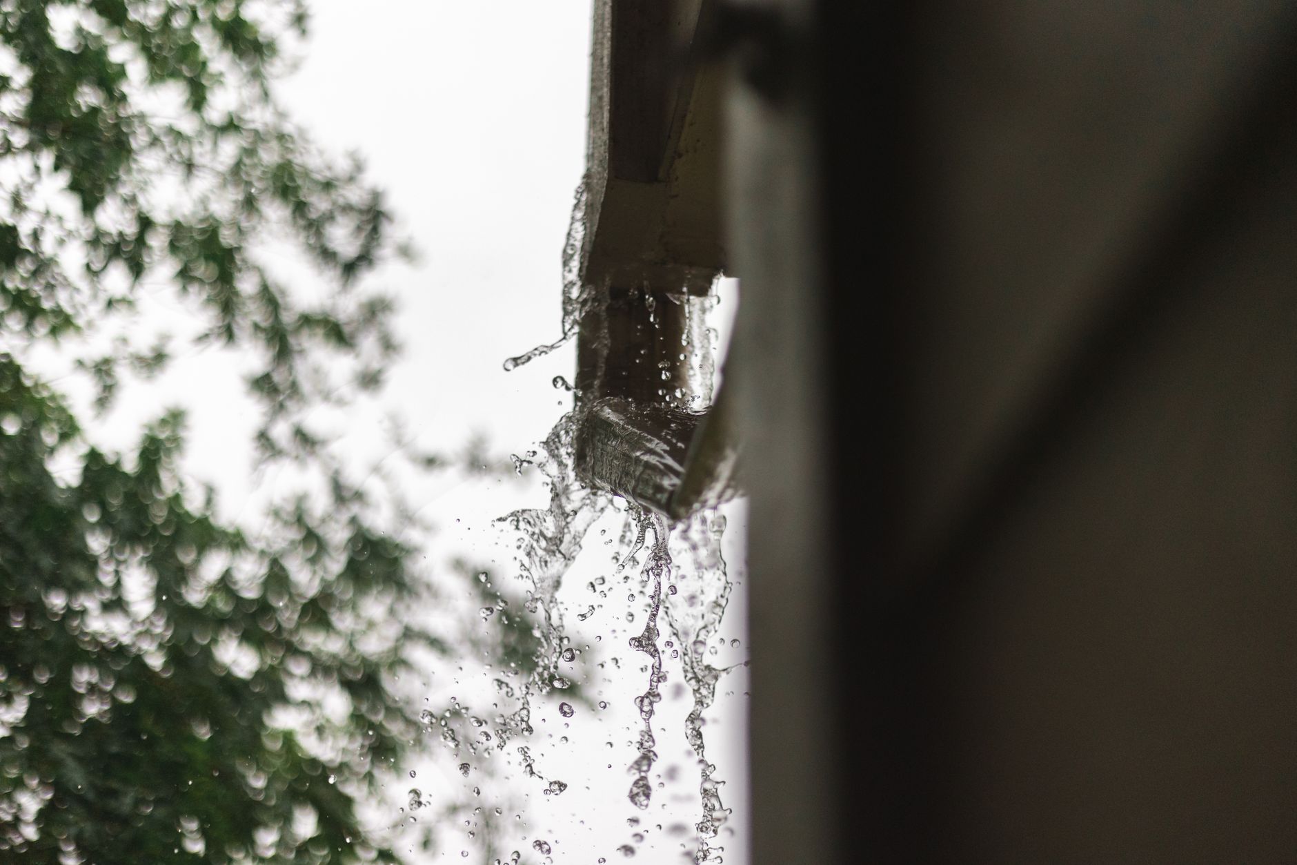 Close up of rainwater pouring from a gutter, captured during a rainfall in Houston.