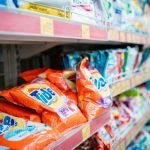 Vibrant selection of laundry detergents on a supermarket shelf, showcasing brands and variety.