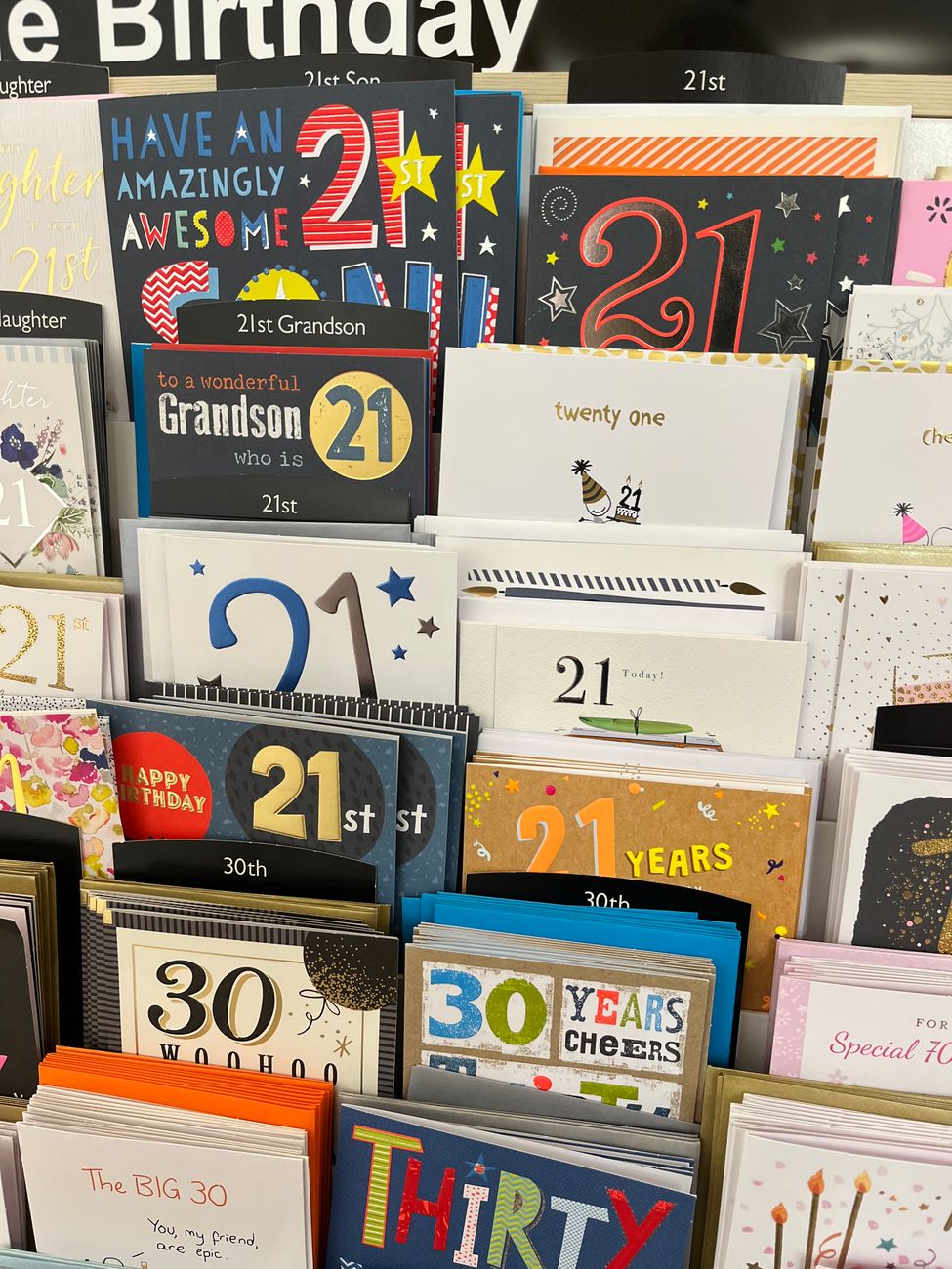 A vibrant assortment of 21st and 30th birthday greeting cards on display.