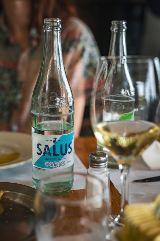 Close up of Salus water and wine glasses on a restaurant table in Uruguay.