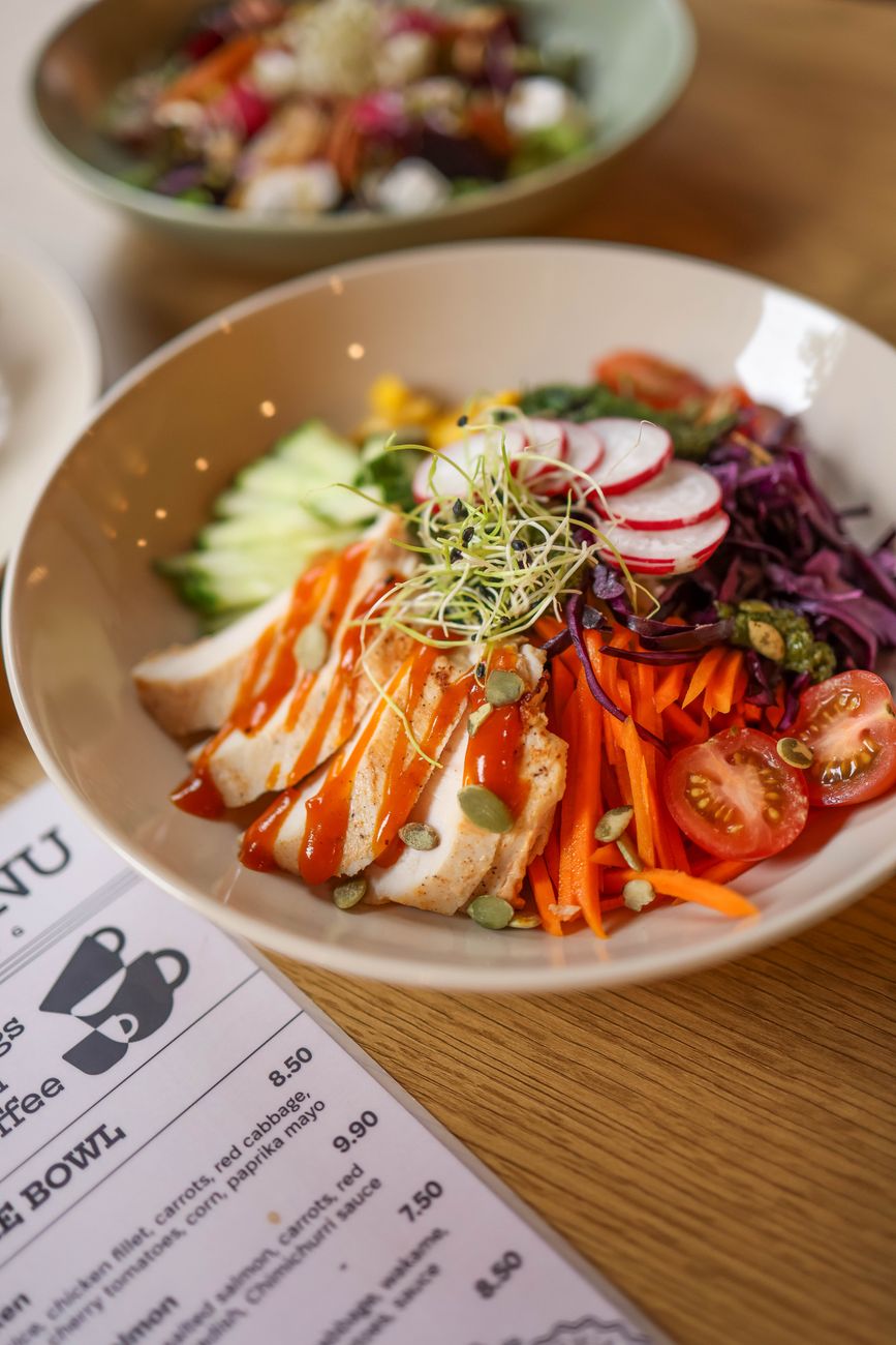 Vibrant vegetable bowl with chicken and dressing, perfect for a healthy meal.