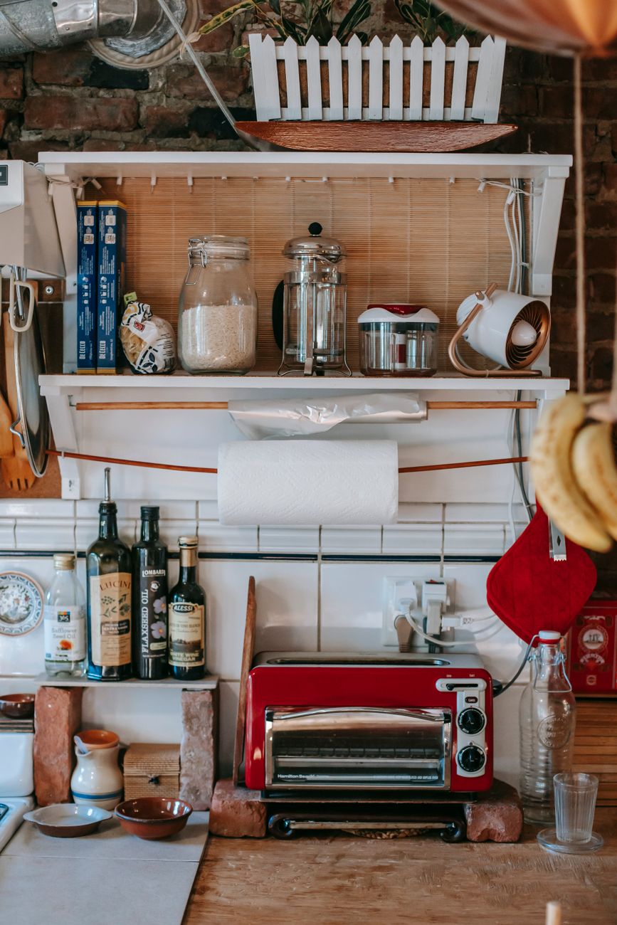 Interior of kitchen with wooden table and different appliances for cooking and kitchenware