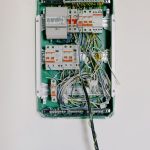 Switchboard with wires connected to electrical switches with circuit breakers installed on white wall
