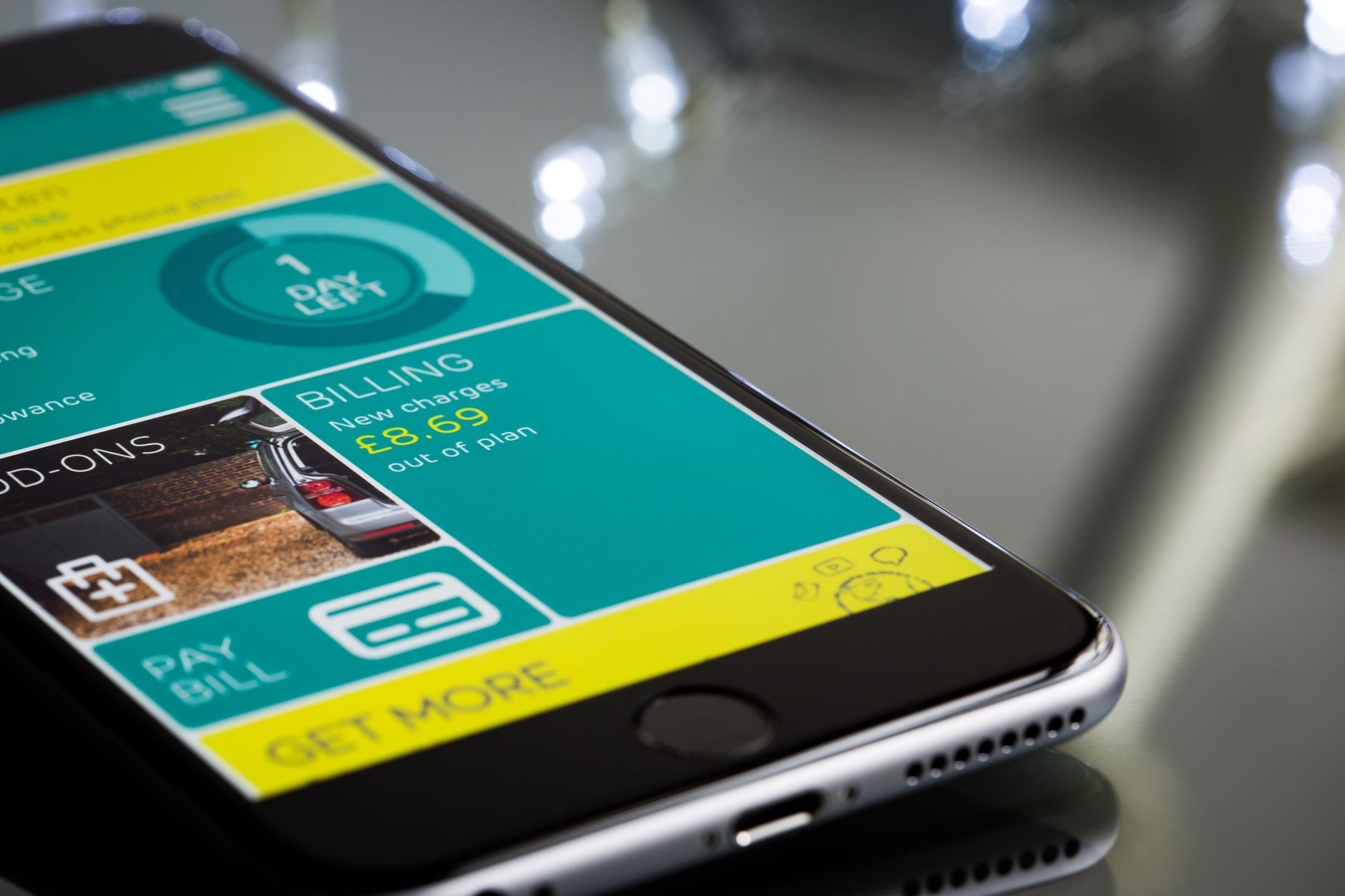 Close up of a smartphone displaying a billing app interface on a reflective surface.