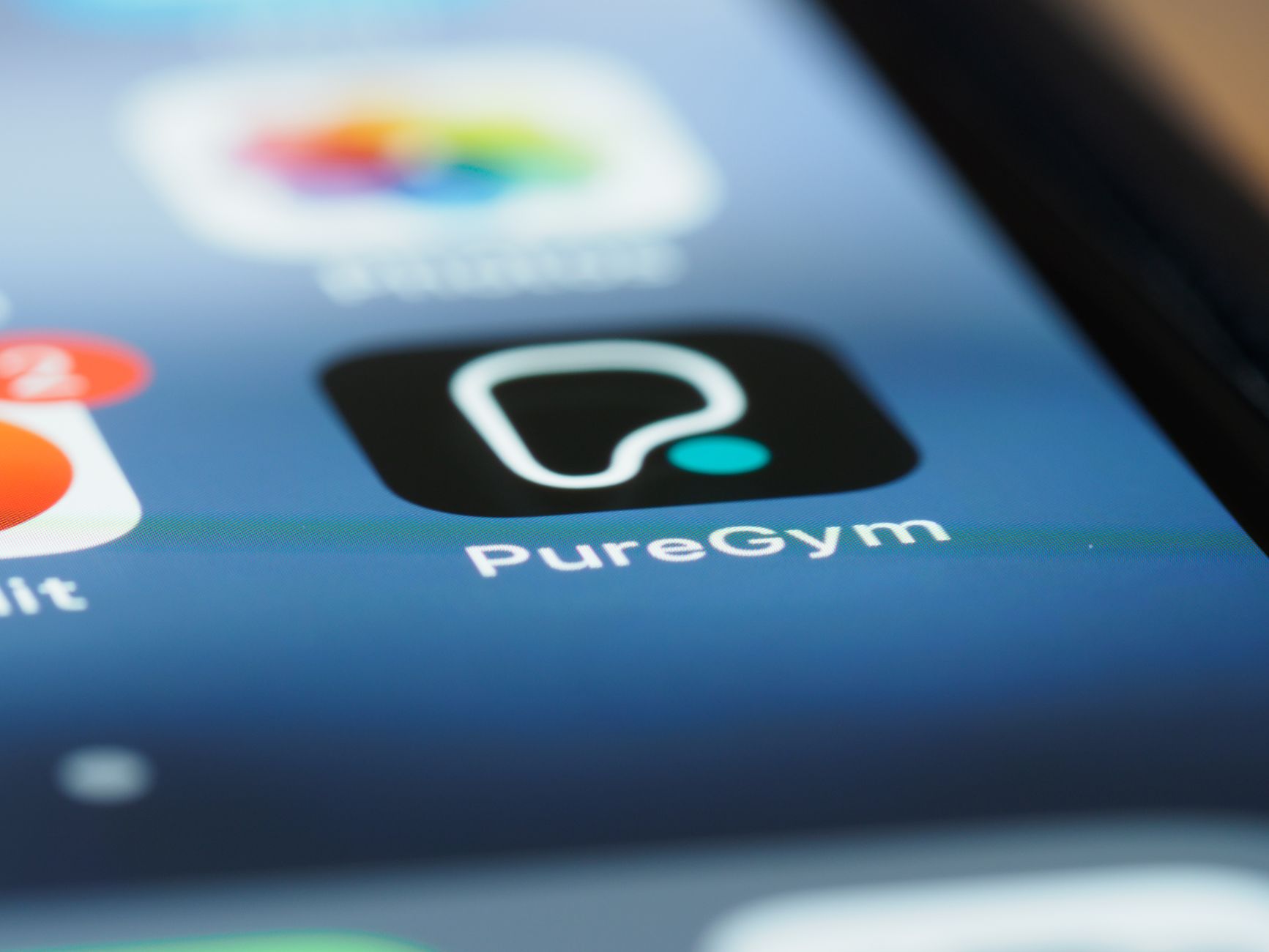 Detailed close up photo of the PureGym app icon on a smartphone screen, highlighting modern technology.