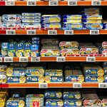 Vibrant selection of canned fish in a French supermarket aisle.