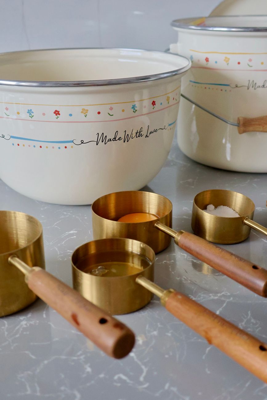 Stylish kitchen setup with vintage mixing bowls and gold measuring cups.