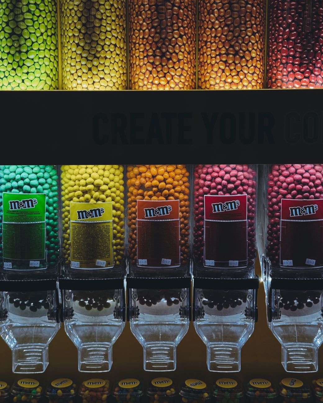 Vibrant display of M&amp;amp;amp;M candies in a store dispenser, highlighting colorful confectionery.