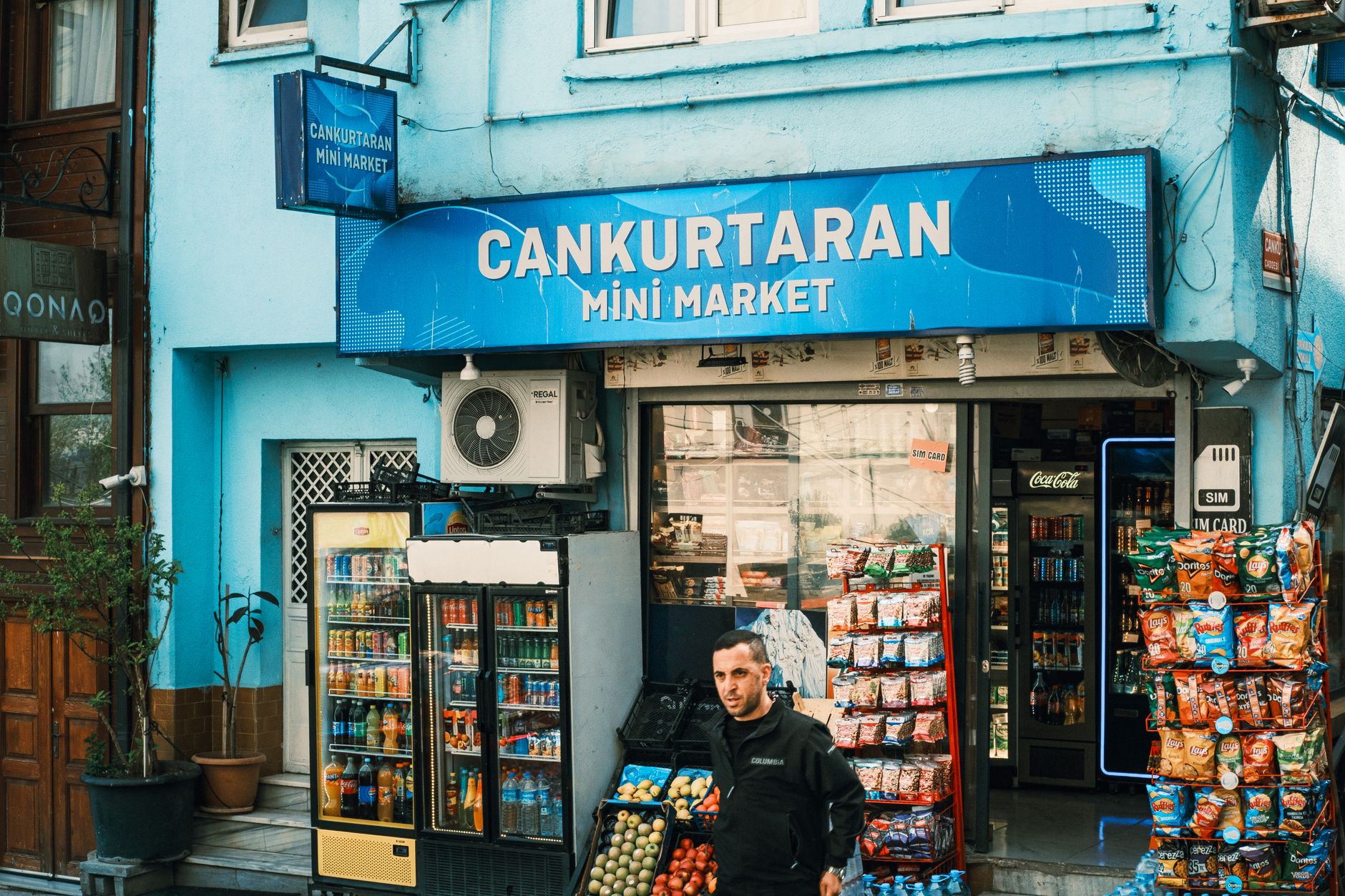 View of Cankurtaran Mini Market with vivid facade and various snacks and drinks on display.