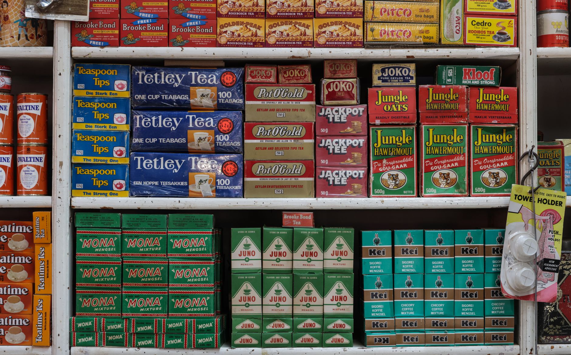 Colorful vintage grocery store shelf with tea and assorted products.