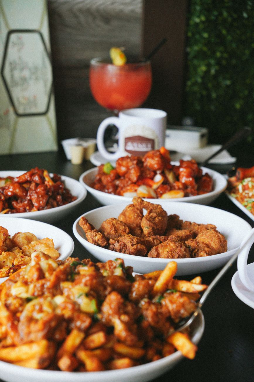 Delicious fried chicken plates with sides and drinks on a restaurant table.